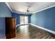 Spacious bedroom featuring hardwood floors, ceiling fan, window and blue painted walls at 5780 Pumkintown Rd, Douglasville, GA 30135