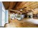 Spacious living room with stone fireplace, spiral staircase, kitchen island, and wood beam ceiling at 5780 Pumkintown Rd, Douglasville, GA 30135