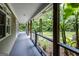 Covered porch with wooden railings, offering a serene view of the landscaped yard and mature trees at 5780 Pumkintown Rd, Douglasville, GA 30135