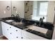 Modern bathroom with a double sink vanity, black countertops, and a tiled shower with black fixtures at 74 Flanders Ct, Douglasville, GA 30134