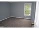 Cozy bedroom with gray carpet and walls, a window offering natural light, and neutral decor at 74 Flanders Ct, Douglasville, GA 30134