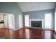 Bright living room featuring a stone fireplace, hardwood floors, and ample natural light at 74 Flanders Ct, Douglasville, GA 30134