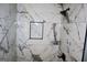 Luxurious shower with marble tiles, modern fixtures, and a built-in niche for toiletries at 74 Flanders Ct, Douglasville, GA 30134