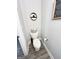 Small, neutral-toned bathroom offers a toilet with woven basket and decorative wall art at 7728 Fawn Cir, Covington, GA 30014