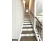 Interior shot of staircase features neutral paint, modern floors and black metal handrail at 7728 Fawn Cir, Covington, GA 30014