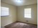 Cozy bedroom with plush carpet flooring, two windows allowing natural light, and neutral walls at 443 S Rays Rd, Stone Mountain, GA 30083