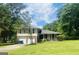 Charming two-story home with a well-manicured front yard and a covered porch, nestled among lush trees at 443 S Rays Rd, Stone Mountain, GA 30083