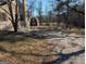 Image shows a house, trees and a distant shed with a white cross with a fenced in yard at 5700 Miles Rd, South Fulton, GA 30349