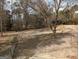 Image shows a view of the backyard with a concrete pad and a building in the distance at 5700 Miles Rd, South Fulton, GA 30349