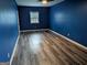 Bedroom with dark blue painted walls and gray woodgrain flooring at 5700 Miles Rd, South Fulton, GA 30349