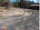 Image shows land with exposed dirt road, some blacktop in the foreground and fencing in the background at 5700 Miles Rd, South Fulton, GA 30349