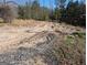 Image shows bare land, a dirt road, and partial fencing in the distance with lots of trees around the area at 5700 Miles Rd, South Fulton, GA 30349