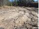 Image shows bare land, a dirt road, and partial fencing in the distance with lots of trees around the area at 5700 Miles Rd, South Fulton, GA 30349