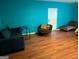 Cozy living room featuring hardwood floors, comfortable furniture, and vibrant turquoise-painted walls at 5700 Miles Rd, South Fulton, GA 30349