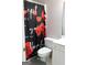Bathroom featuring a toilet, vanity, and a shower curtain with a floral and text design at 5113 Heritage Oaks Sw Ln, Powder Springs, GA 30127
