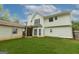 Rear exterior view of home with a well-maintained lawn and a two-story structure under a blue sky at 5113 Heritage Oaks Sw Ln, Powder Springs, GA 30127