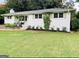 Charming white brick home featuring a lush front lawn and manicured landscaping at 3095 Holbrook Sw Dr, Marietta, GA 30060