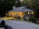 Charming home with professional landscape lighting, beautiful mature trees, and a view of the side deck at 921 Oak Dr, Woodstock, GA 30189