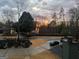 Luxury home at sunset featuring beautiful landscaping and view of the lake at 921 Oak Dr, Woodstock, GA 30189