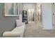 Bright hallway featuring a white tufted bench, modern artwork, and a glimpse into the bathroom at 1818 Butterfly Way, Marietta, GA 30066