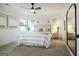 Bright, carpeted main bedroom with paneled wall, ceiling fan, and tufted headboard at 1818 Butterfly Way, Marietta, GA 30066