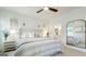 Bright main bedroom with ceiling fan, paneled wall, and ensuite bathroom reflected in mirror at 1818 Butterfly Way, Marietta, GA 30066