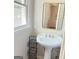Pedestal sink with metallic mirror, window with ledge and dark storage at 401 Mt. Tabor Church Rd., Dallas, GA 30157