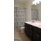 Well-lit bathroom with double vanity sinks and dark wood cabinets plus a blue patterned shower curtain at 878 W Union Grove Cir, Auburn, GA 30011