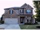 Traditional brick home featuring a two-car garage and well-maintained lawn at 878 W Union Grove Cir, Auburn, GA 30011
