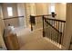 Carpeted upstairs hallway with wood railing overlooking the stairway and with views into the bathroom at 878 W Union Grove Cir, Auburn, GA 30011