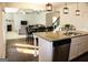 View of the modern kitchen with granite countertops, island with sink, and adjoining living room at 878 W Union Grove Cir, Auburn, GA 30011