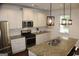 Well-equipped kitchen features granite counters, stainless steel appliances, and stylish pendant lights at 878 W Union Grove Cir, Auburn, GA 30011