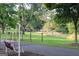 Scenic park view featuring a charming swing seat, walking path, and distant playground in a serene setting at 878 W Union Grove Cir, Auburn, GA 30011