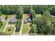 Aerial view of a single-Gathering home with lush landscaping in a wooded area; property outlined in white at 150 Cold Harbor Ct, Sharpsburg, GA 30277