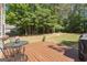 Cozy back deck with a table, chairs, and a grill, surrounded by a green lawn at 150 Cold Harbor Ct, Sharpsburg, GA 30277
