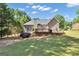 Exterior of the home with a large wooden deck and a lush green backyard at 150 Cold Harbor Ct, Sharpsburg, GA 30277