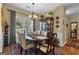 Elegant dining room with a large window, hardwood floors, and a sophisticated chandelier at 150 Cold Harbor Ct, Sharpsburg, GA 30277