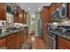 Well-equipped kitchen with stainless steel appliances, granite counters, and wood cabinets leading to a hallway at 150 Cold Harbor Ct, Sharpsburg, GA 30277