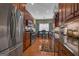 Traditional-style kitchen with stainless steel appliances, granite counters, and hardwood floors leading to a dining area at 150 Cold Harbor Ct, Sharpsburg, GA 30277
