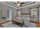 Comfortable main bedroom with a tray ceiling, large windows, hardwood flooring, and neutral paint at 150 Cold Harbor Ct, Sharpsburg, GA 30277