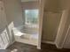 Bathroom with a large soaking tub and a glass-enclosed shower at 5678 Mill View Way, Lithonia, GA 30038