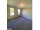 Bedroom featuring plush carpeting and ample natural light from two large windows at 5678 Mill View Way, Lithonia, GA 30038
