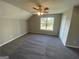 Spacious bedroom featuring plush carpeting, a ceiling fan, and a window providing natural light at 5678 Mill View Way, Lithonia, GA 30038