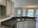 Well-lit kitchen featuring stainless steel sink, grey cabinets, and modern pendant lighting at 5678 Mill View Way, Lithonia, GA 30038
