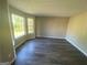 Open living room featuring hardwood floors, neutral walls, and large windows letting in natural light at 5678 Mill View Way, Lithonia, GA 30038