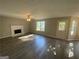 Open-concept living room with a fireplace, hardwood floors, neutral walls, and a ceiling fan at 5678 Mill View Way, Lithonia, GA 30038