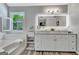 Bright bathroom featuring a double sink vanity with an illuminated mirror and natural light at 503 Atwood Cir, Peachtree City, GA 30269