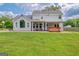 Back exterior view of the home showcasing a well-manicured lawn, brick patio, hot tub and pergola at 503 Atwood Cir, Peachtree City, GA 30269