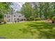 Expansive backyard featuring a pristine lawn, swimming pool, patio area, and mature trees at 111 Biltmore Trce, Peachtree City, GA 30269