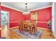 Dining room with hardwood floors, red walls, and stylish light fixture at 111 Biltmore Trce, Peachtree City, GA 30269